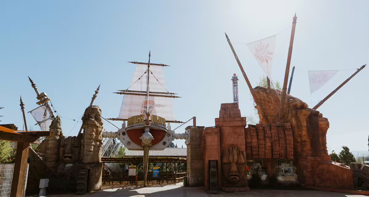 MagicLand Amusement Park entrance with pirate ship themed gate and flags, main entry for park tickets and rides