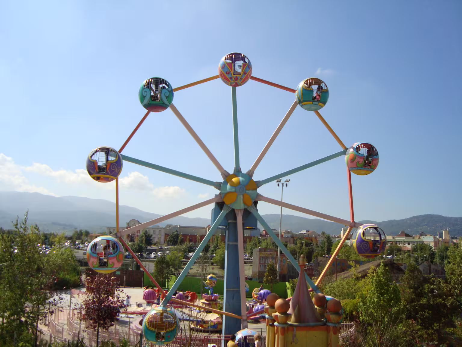 Colorful Ferris wheel ride at MagicLand Amusement Park, a family-friendly attraction with scenic views