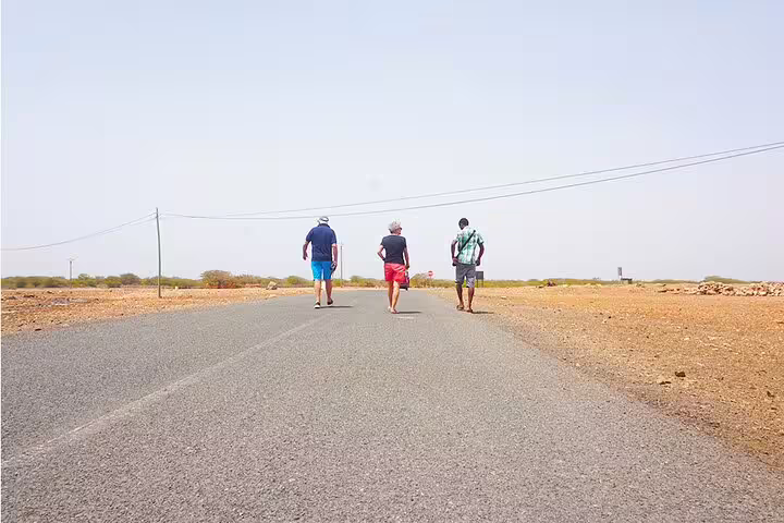 Travelers walking on Maio island road, route between Harbour and Calheta on private transfer in Cape Verde