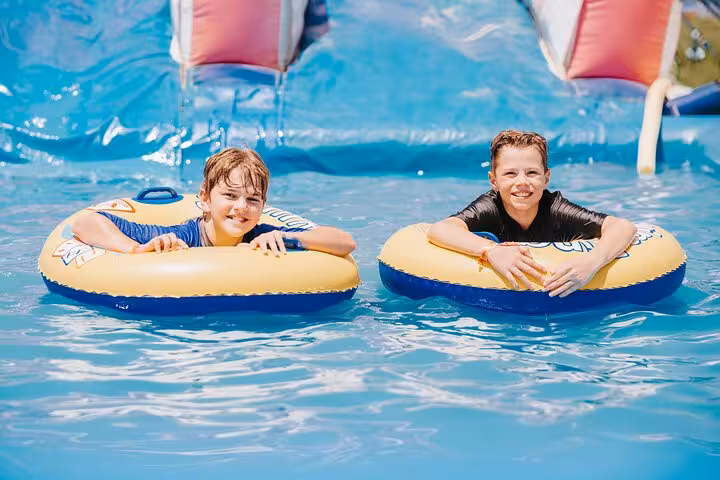 Two boys on inflatable rings in Makadi Water World Aqua Park pool, Hurghada day use and lunch package