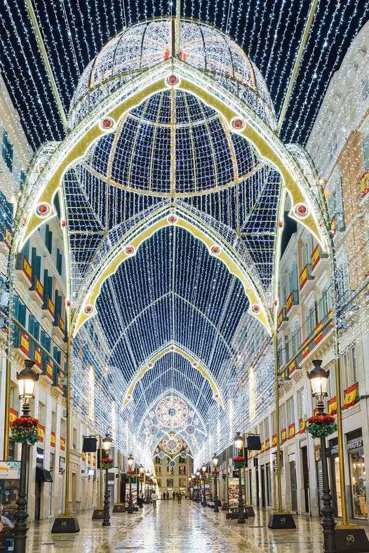 Stunning Christmas lights illuminate Malaga's street with intricate arch designs and festive decorations.