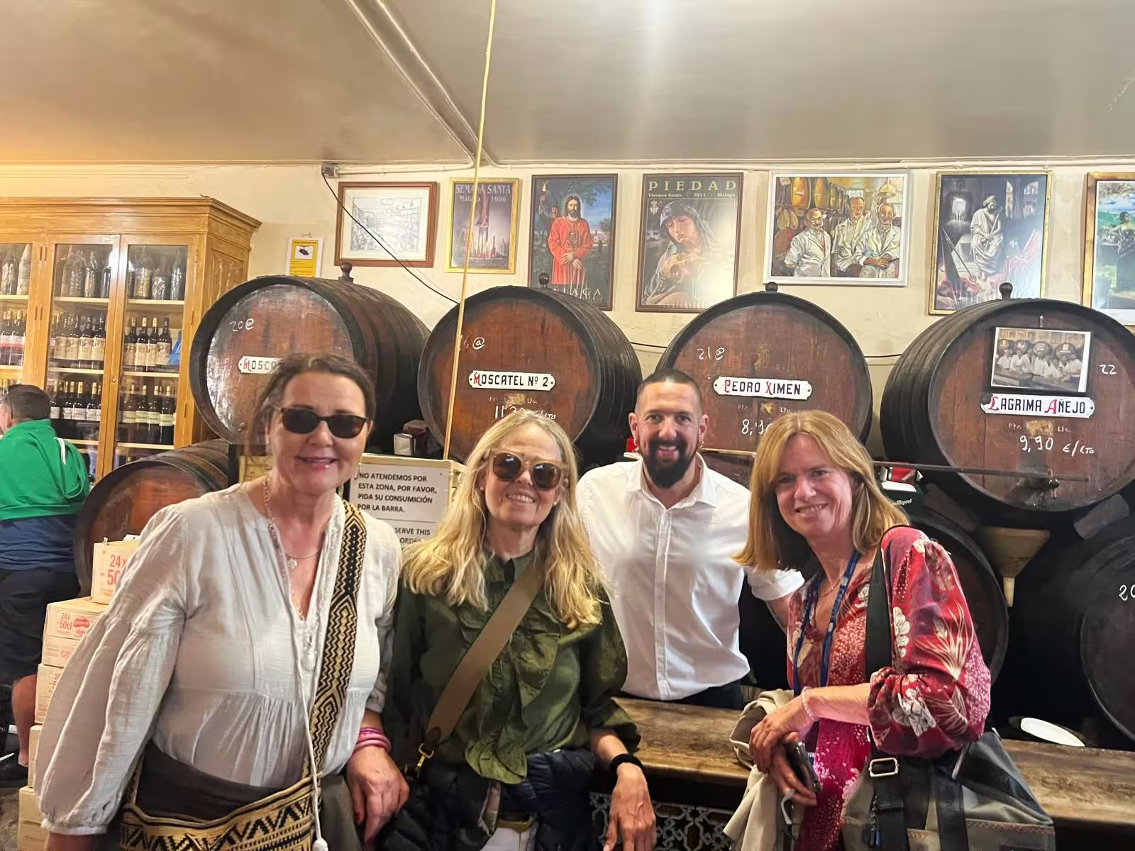 Guests at a Malaga bodega with wine barrels during a private Malaga and Mijas full-day trip with hotel pick-up