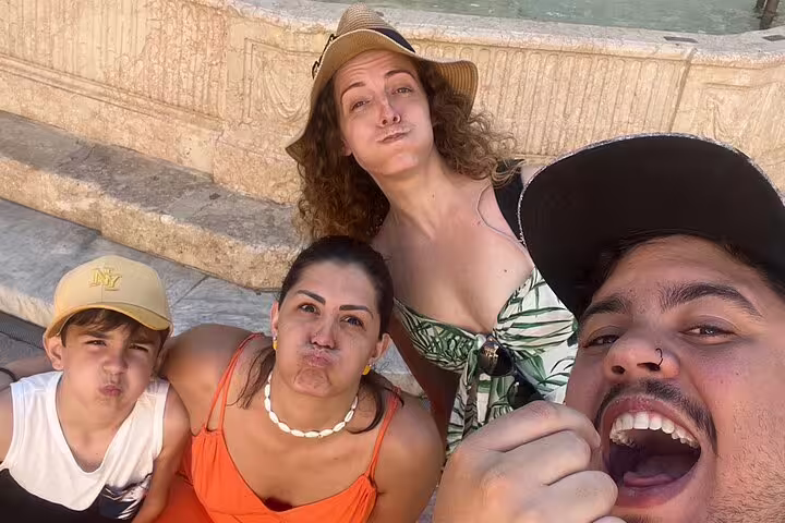 Friends taking a selfie during Malaga scavenger hunt and sights self-guided tour by a fountain in the old town