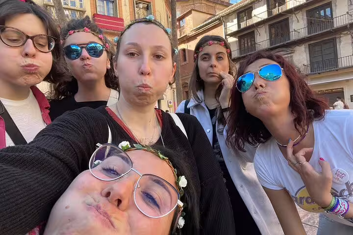 Friends posing in Malaga old town during a self-guided scavenger hunt tour, exploring plazas and landmarks