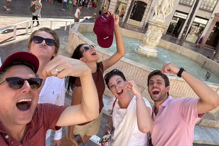Team selfie cheering at Malaga city center fountain on a self-guided scavenger hunt and sights tour