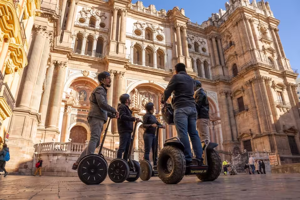Visitors on Segways admiring the stunning architecture of Malaga Cathedral during a guided city tour.