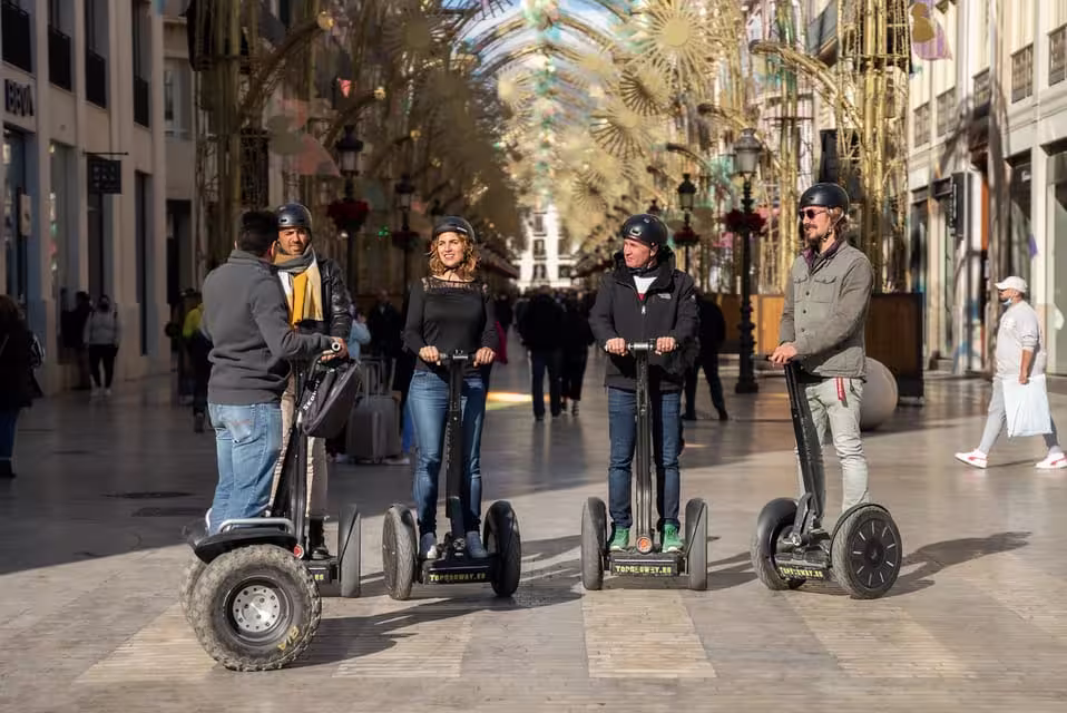 Tourists enjoy a guided Segway tour through the historic streets of Malaga, highlighting local monuments and attractions.