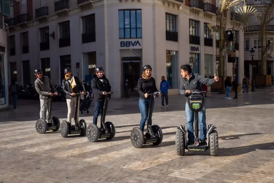 Group enjoying a guided Segway tour through historic streets of Malaga, perfect for sightseeing and exploring monuments.