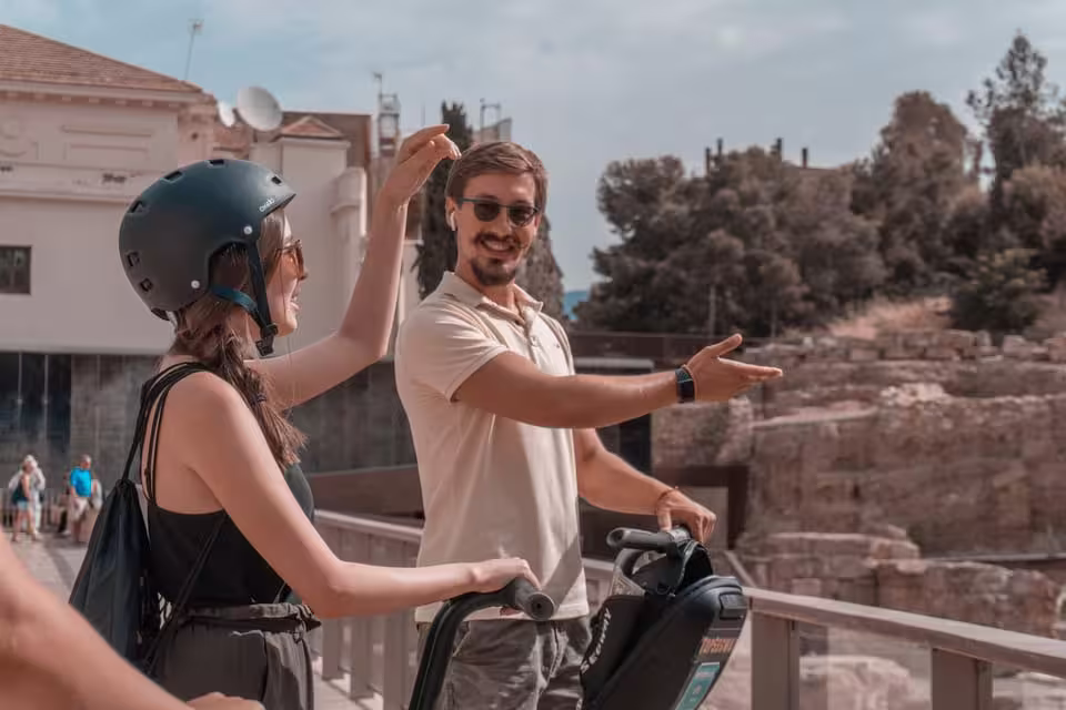 Tourists enjoy a guided Segway tour exploring historical landmarks in Malaga with scenic views.