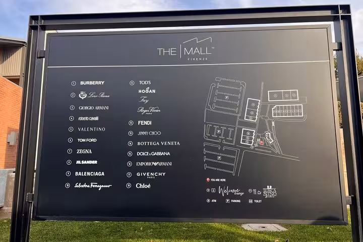 Directory board at The Mall Firenze listing luxury brands like Burberry and Fendi with a site map included.