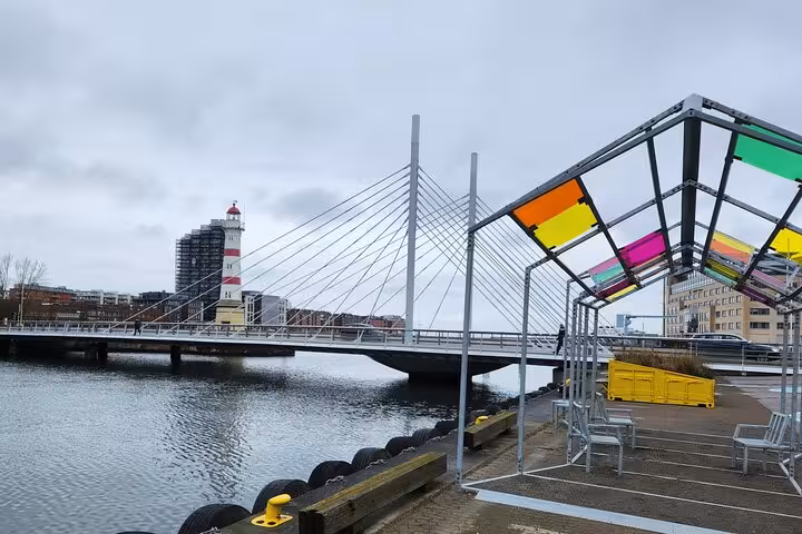 Modern bridge and colorful canopy by the water in Malmö, showcasing popular landmarks on a 4-hour city tour.