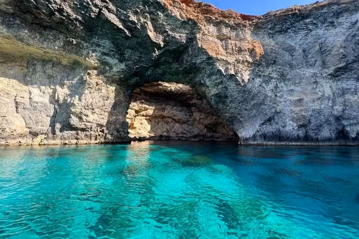 Boat view into Malta sea cave with turquoise water on Gozo Comino Blue Lagoon half-day cruise tour