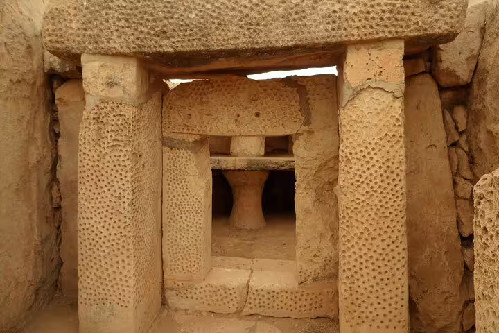 Ancient stone structure of Malta's megalithic temples, showcasing intricate carvings, explored on a full-day local sightseeing tour.