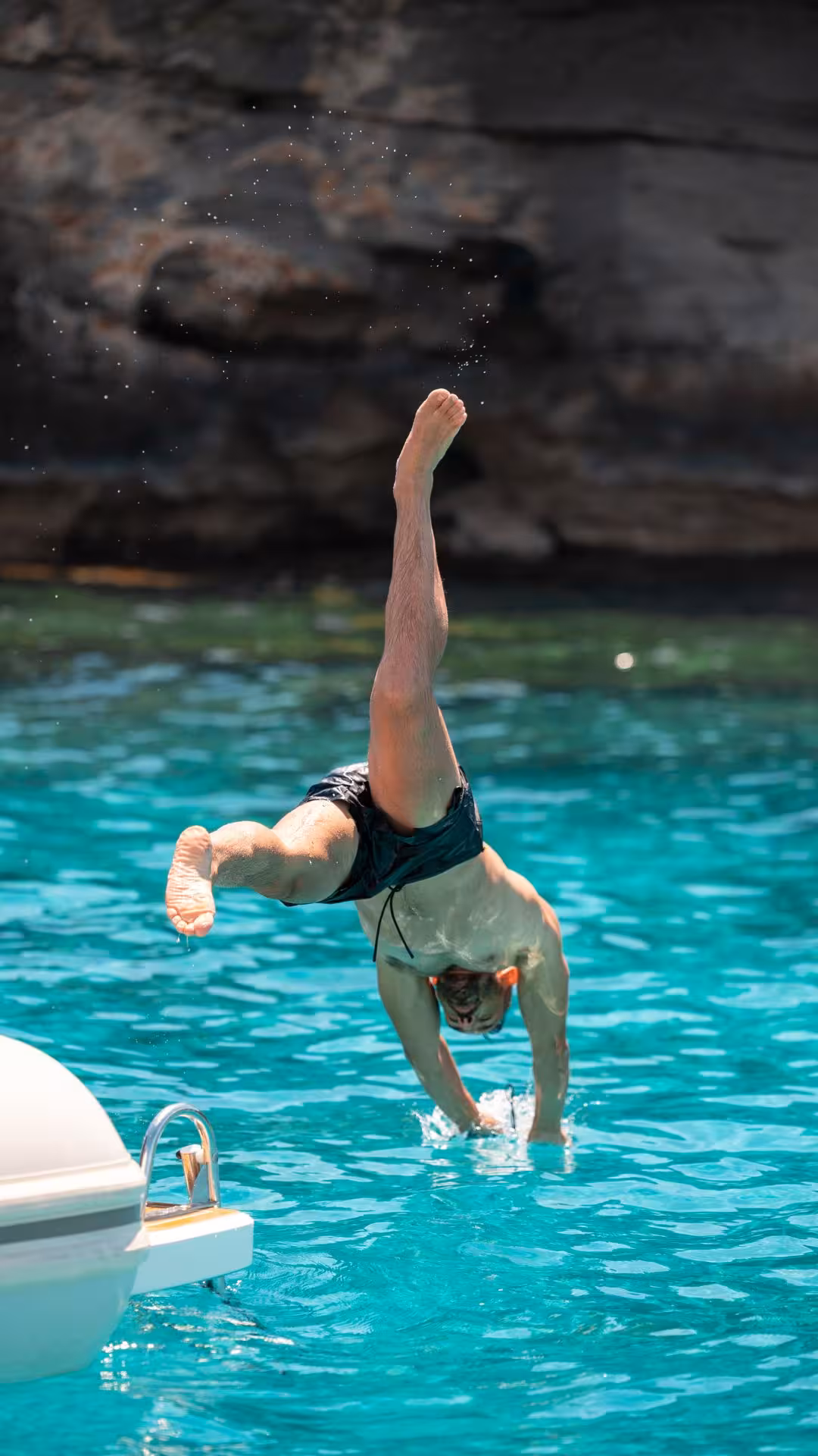 Man diving into the crystal-clear waters off a dinghy near the scenic coast of Favignana during an exciting tour.