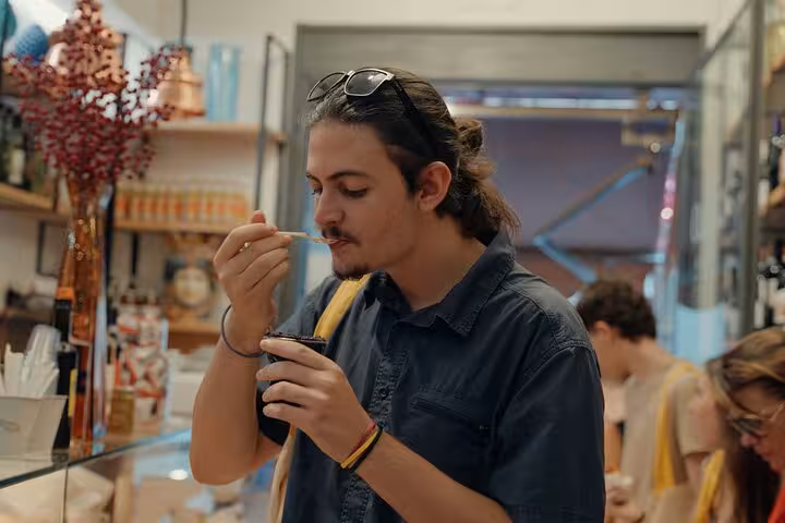 Man savoring artisanal gelato in a Florence gelato shop, enjoying flavors during a city center culinary walk.
