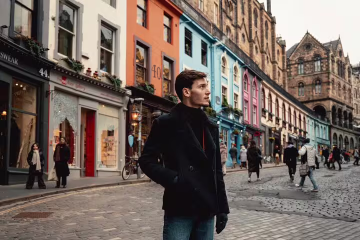 Man exploring vibrant Victoria Street, ideal for private photoshoots with colorful Edinburgh backdrop.
