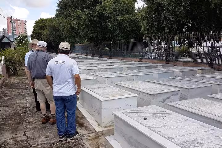 Visitors with guide walking through Manaus Jewish cemetery, key site on Jewish heritage tour in Amazonas