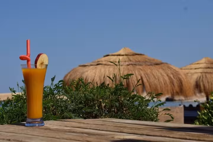 Fresh mango juice on a beach table at Sharm El Naga, relaxing stop on semi-private trip from Hurghada