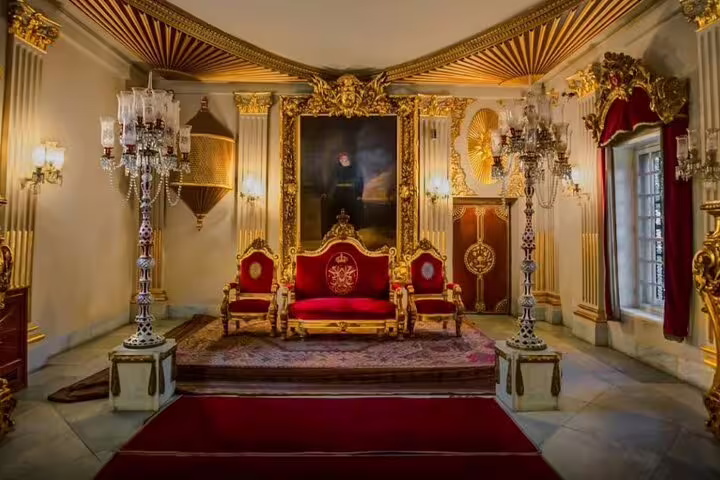 Lavish throne room inside Manial Palace in Cairo with gilded décor, chandeliers, and royal seating