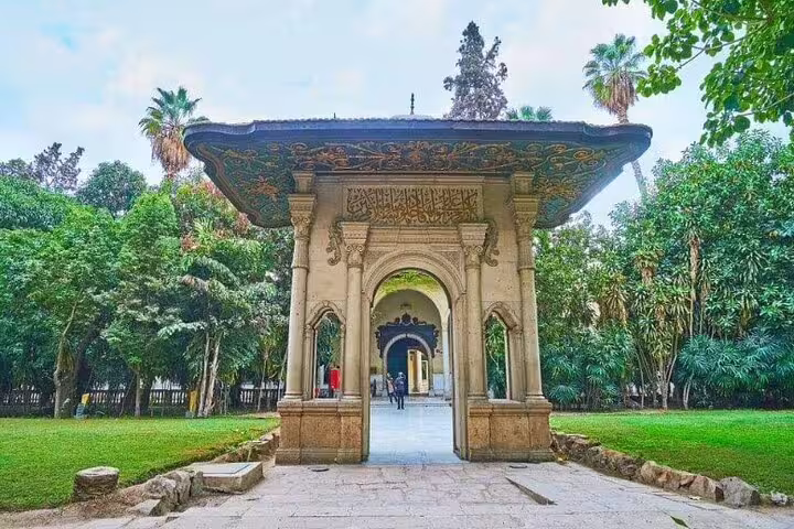 Garden entrance gate of Manial Palace in Cairo, framed by lush greenery on a day tour with Cairo Tower visit