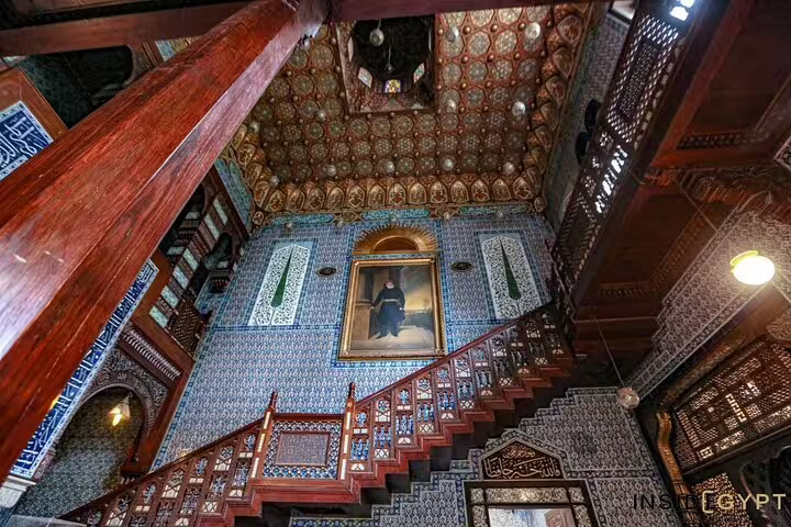 Ornate Manial Palace interior with tiled walls, wooden staircase, and historic portrait on Cairo day tour