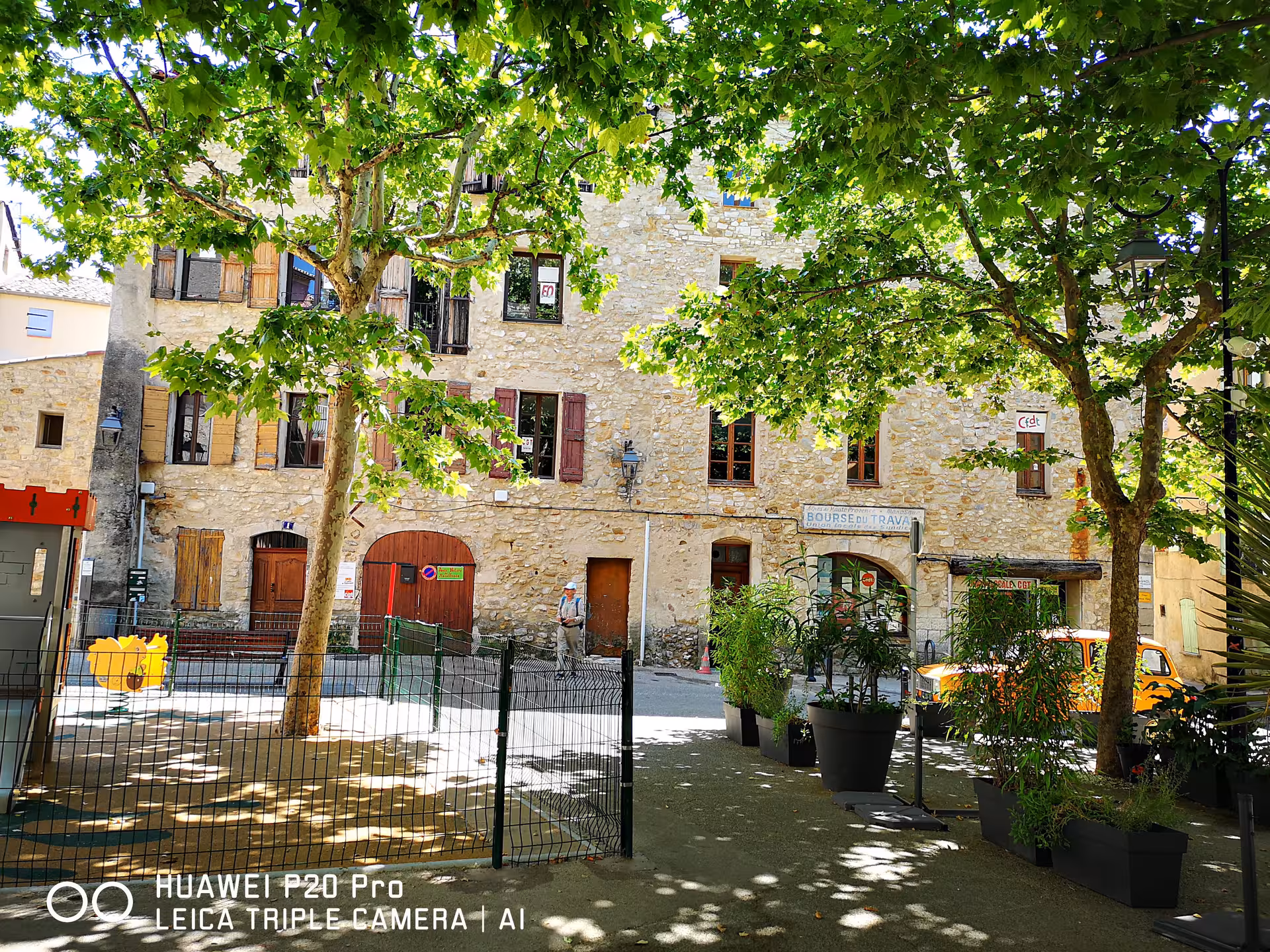 Shaded Manosque square with stone houses, Provence village stop on private Marseille shore excursion day trip