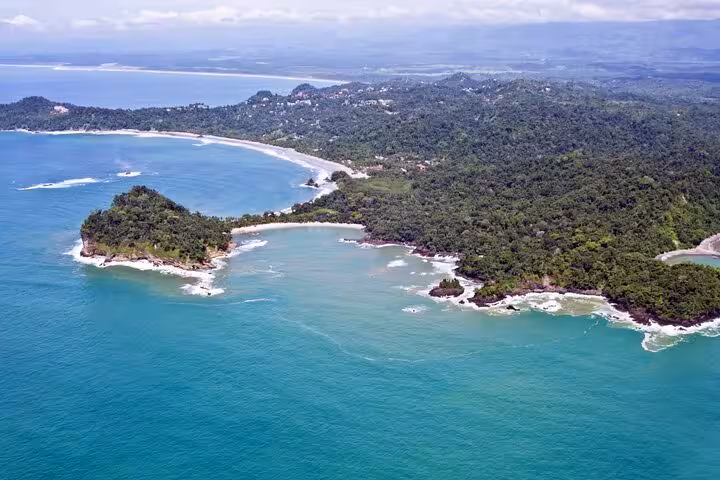 Aerial view of Manuel Antonio National Park's lush coastline and turquoise waters, perfect for a guided nature tour.