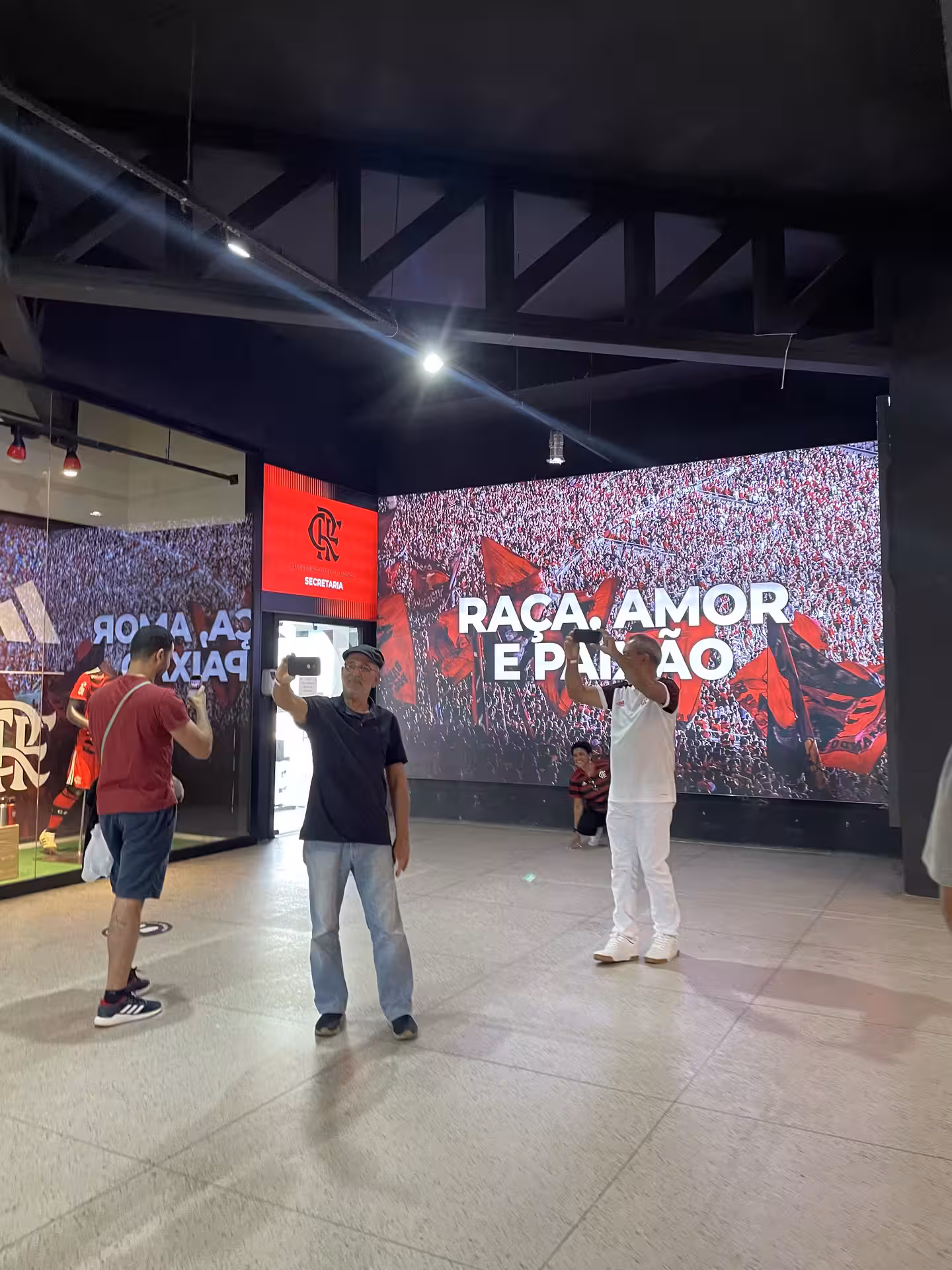 Visitors explore Maracanã Stadium with vibrant Flamengo mural, part of the Rio Football Experience tour.
