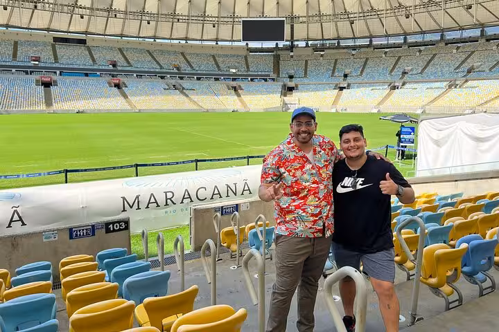 Visitors pose in Maracanã Stadium stands with pitch view on Rio de Janeiro guided stadium tour with local