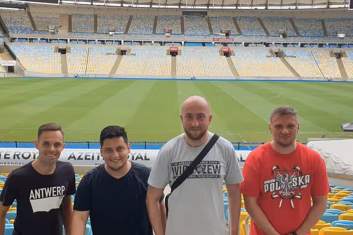 Visitors posing in Maracanã Stadium stands with panoramic view of the pitch during a guided Rio de Janeiro tour