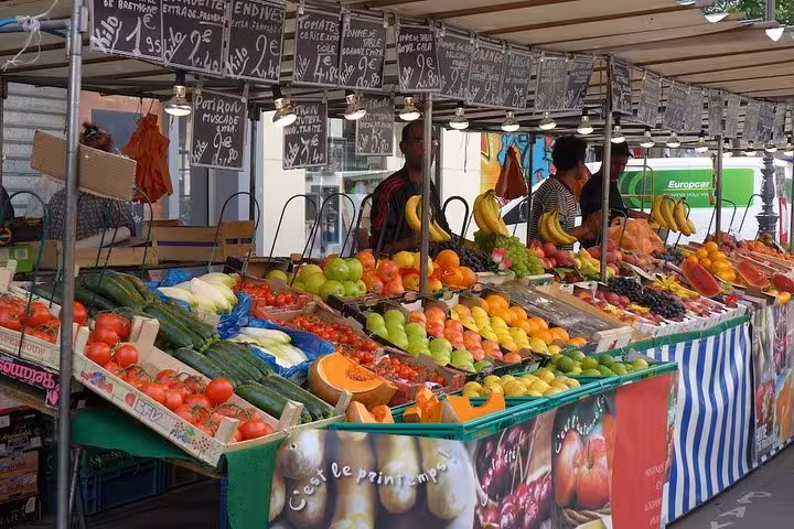 Vibrant fruit and vegetable stall at a local market near the Marais, showcasing fresh produce for walking tour visitors.