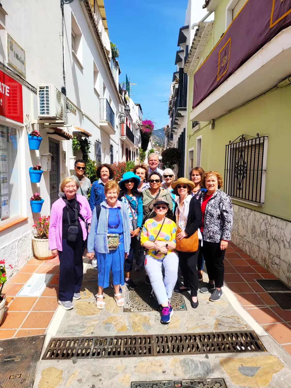 Small group exploring a narrow whitewashed Mijas village street on a private full-day tour with hotel pick-up