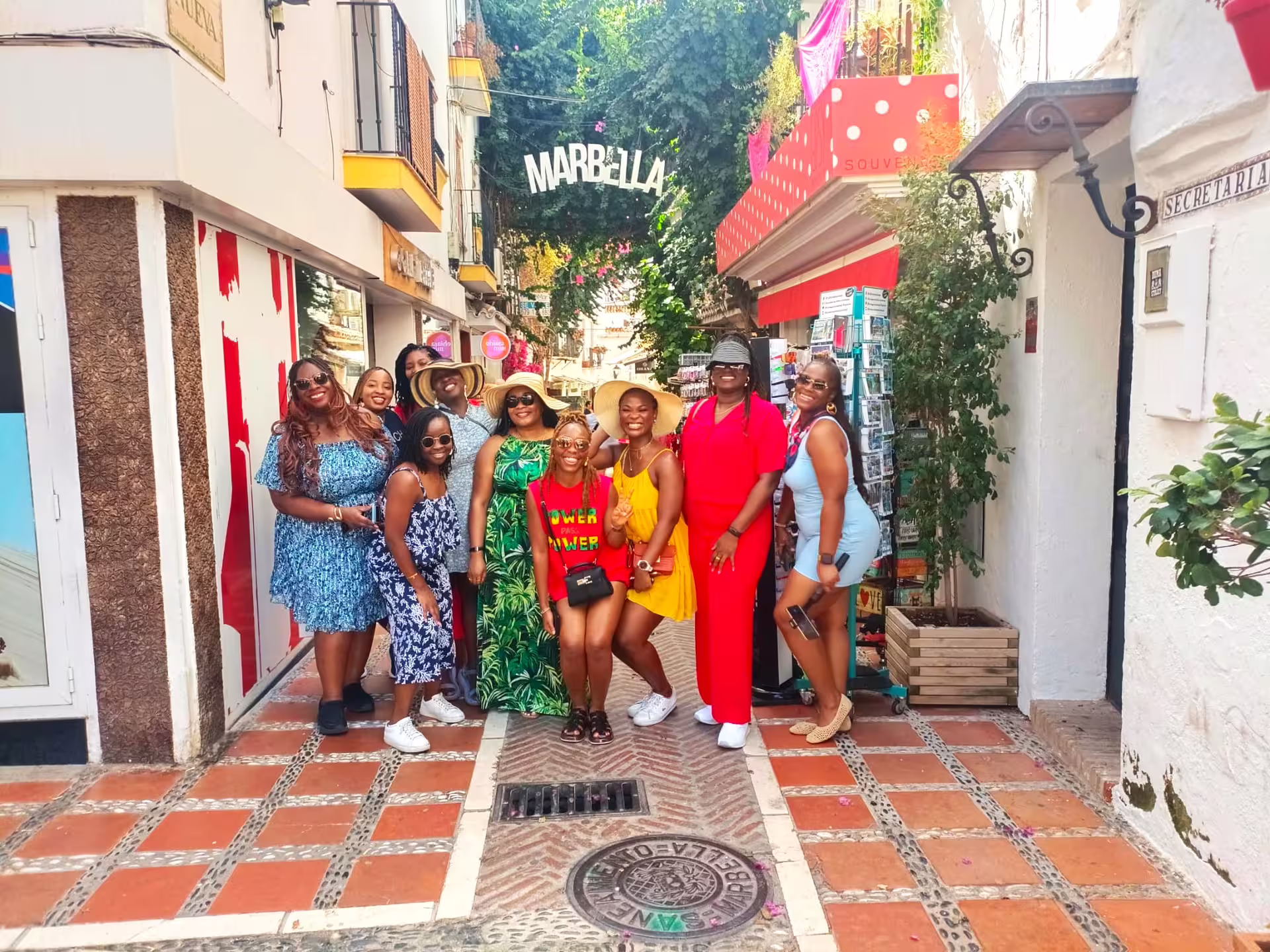 Group photo under Marbella sign in Old Town street, a highlight of a private Marbella tour from Malaga