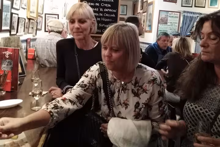 Group enjoying authentic tapas at a lively Marbella bar on the Original Marbella Tapas Adventure tour.