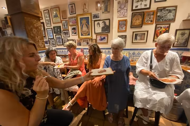Guests savoring delicious tapas in a cozy Marbella restaurant, surrounded by vibrant art and culture.