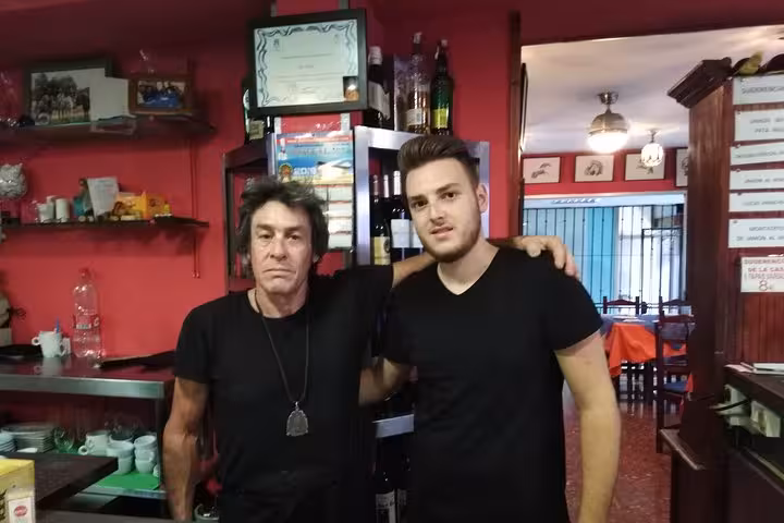 Two staff members pose in a vibrant Marbella restaurant, ready to serve authentic tapas dishes.