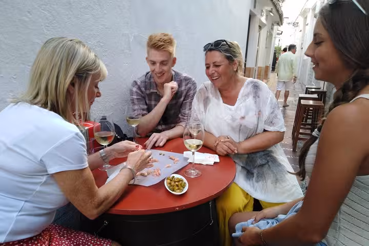 Group enjoying wine and tapas in Marbella's charming streets during a guided food tour.