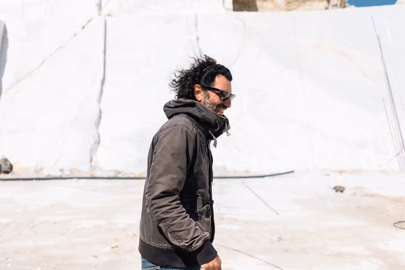 Smiling local guide walking through a bright white marble quarry during the Marble World experience tour