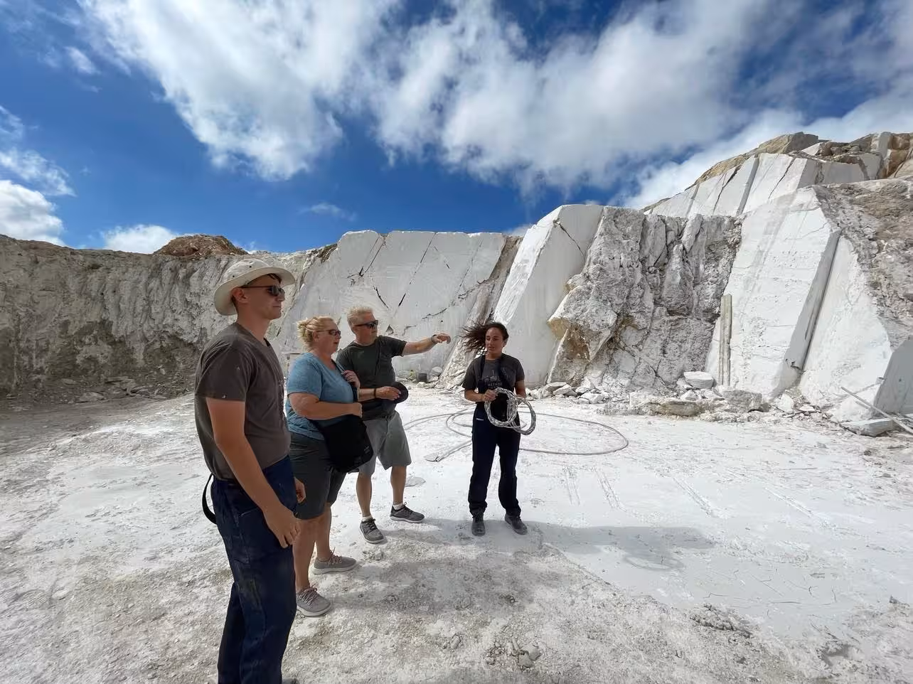 Guided Marble World quarry visit with travelers by bright white marble cliffs, learning how stone is extracted