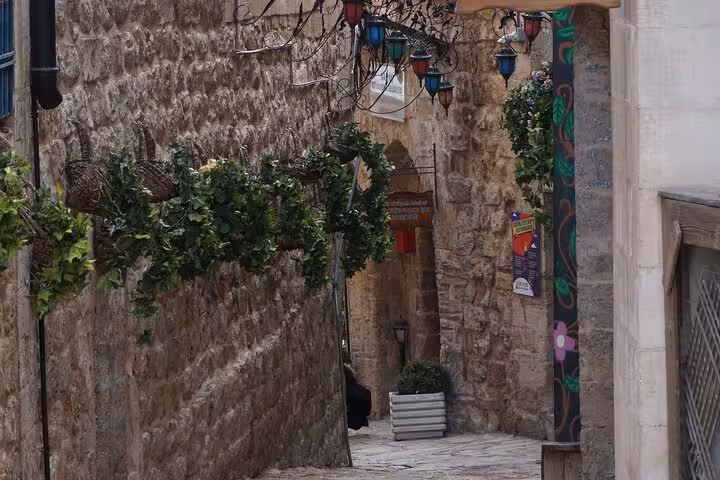 Charming stone alley in Mardin Old Town with colorful lanterns, vines, on private guided city tour