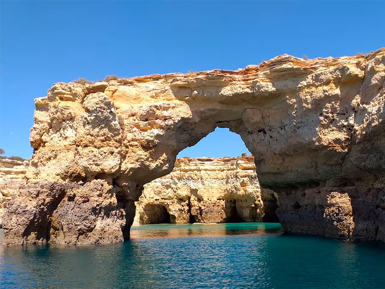 Natural rock arch over turquoise waters near Benagil Caves on an Algarve luxury catamaran boat tour