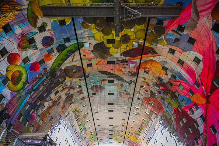 Colorful Markthal Rotterdam ceiling artwork inside market hall, a must-see stop on a local walking tour