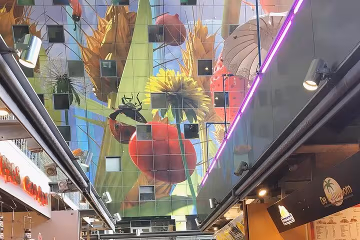 Markthal Rotterdam interior on private sightseeing tour, colorful ceiling mural above food stalls in the city center