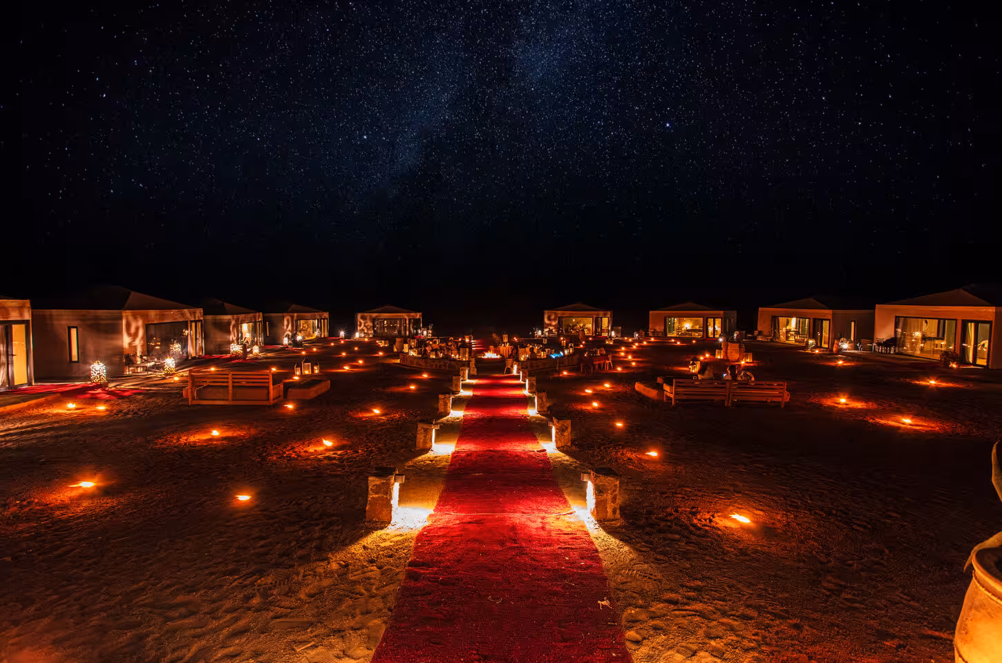 Starlit luxury desert camp with glowing lanterns and tents in Merzouga on a Marrakech to Fes 3-day desert tour.