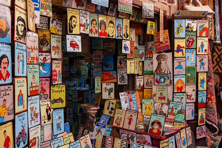 Vibrant Marrakech Medina art stall with handmade posters, explored on full-day sightseeing with a local