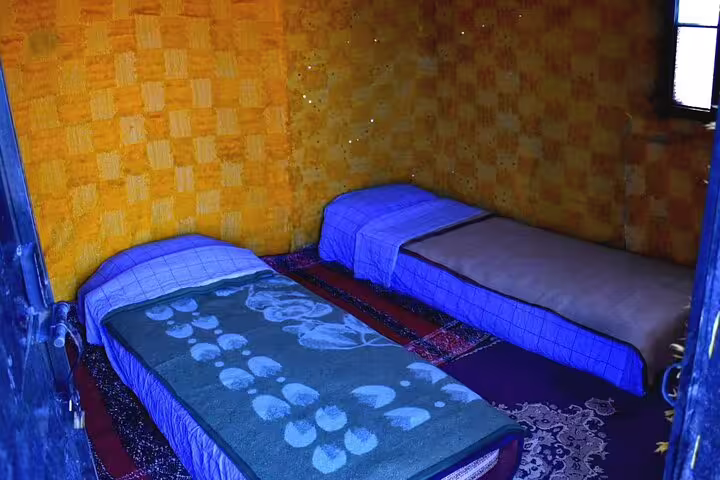Twin beds in a simple desert lodge room on the private 2-day Marrakech to Zagora desert tour