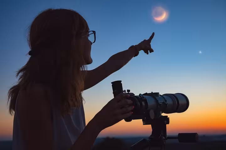 Silhouette pointing at crescent moon during Marsa Alam jeep stargazing tour with Bedouin night and dinner
