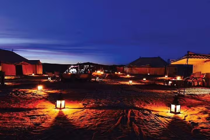 Lantern-lit desert camp at dusk on Marsa Alam Jeep safari adventure tour with Bedouin dinner and show