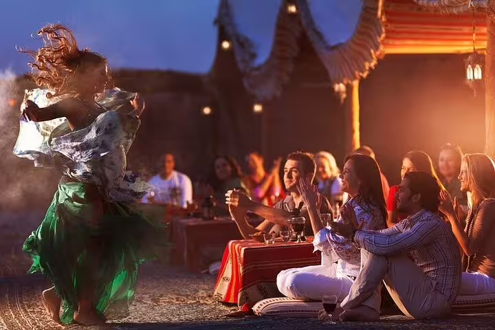 Guests watching belly dance at desert camp dinner during Marsa Alam Jeep safari adventure tour with show