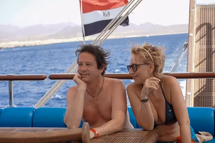 Couple relaxing on pirates sailing boat cruise from Marsa Alam, Red Sea views on way to Turtle Bay